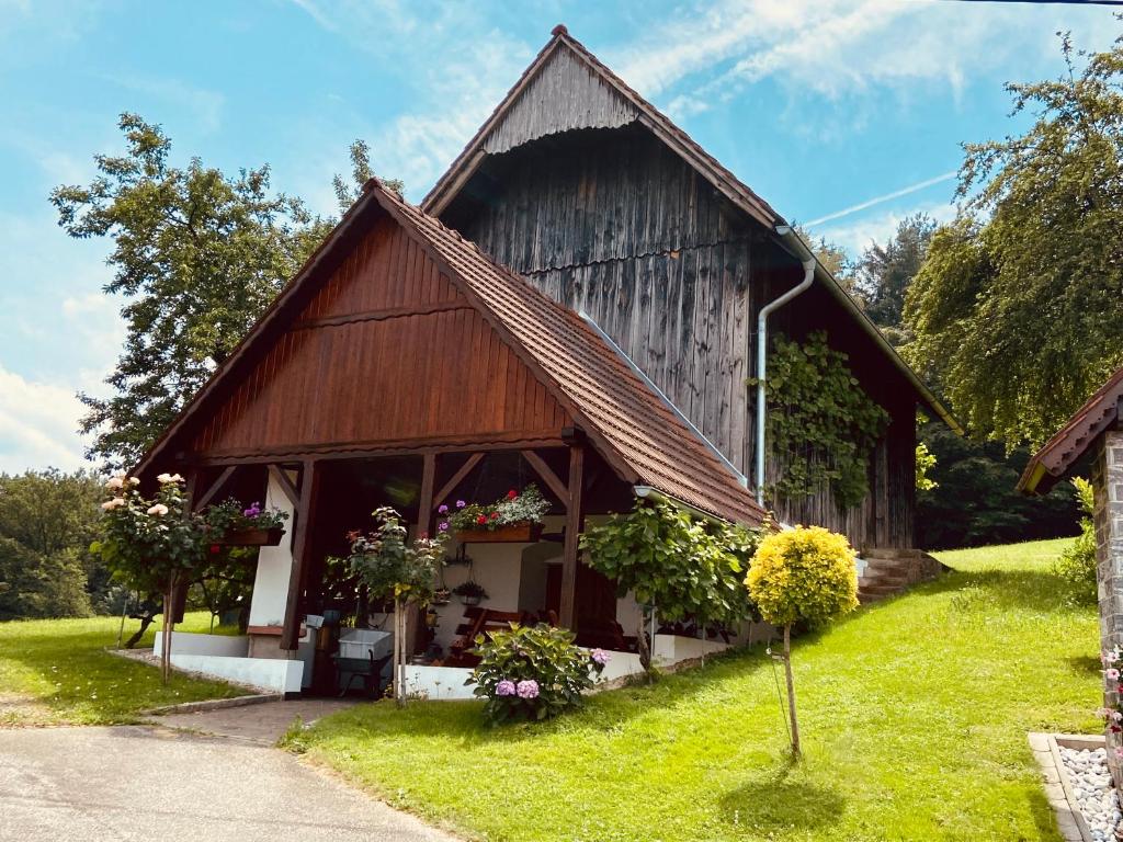 an old barn with flowers in front of it at KOASAHOF Ferienwohnung in Oberhaag