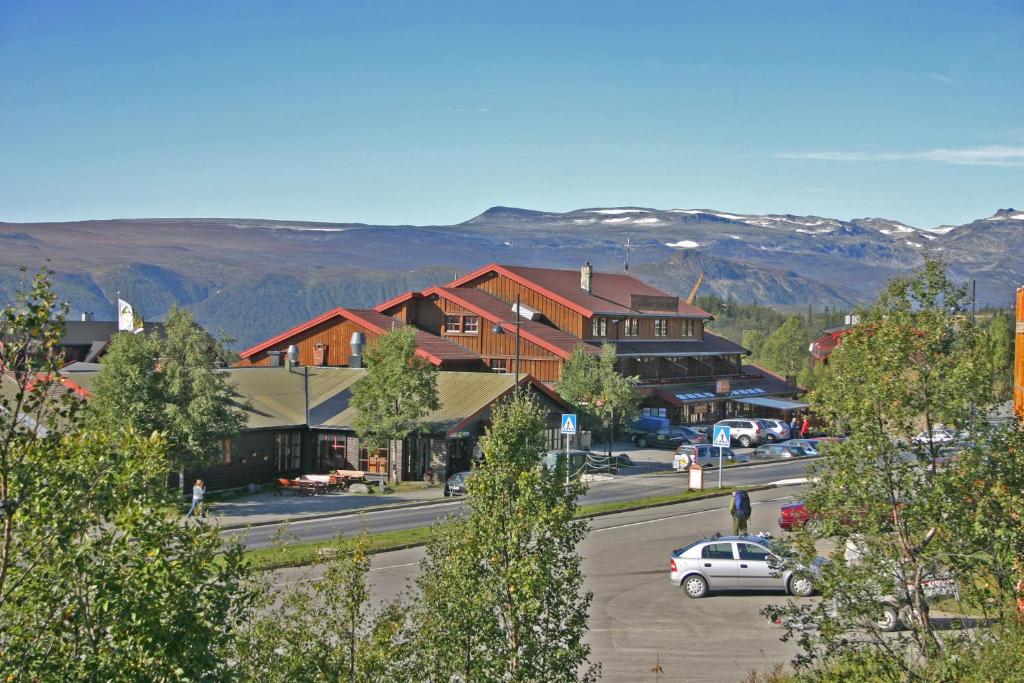 a town in the mountains with cars parked in a parking lot at Bergo Rom in Beitostøl