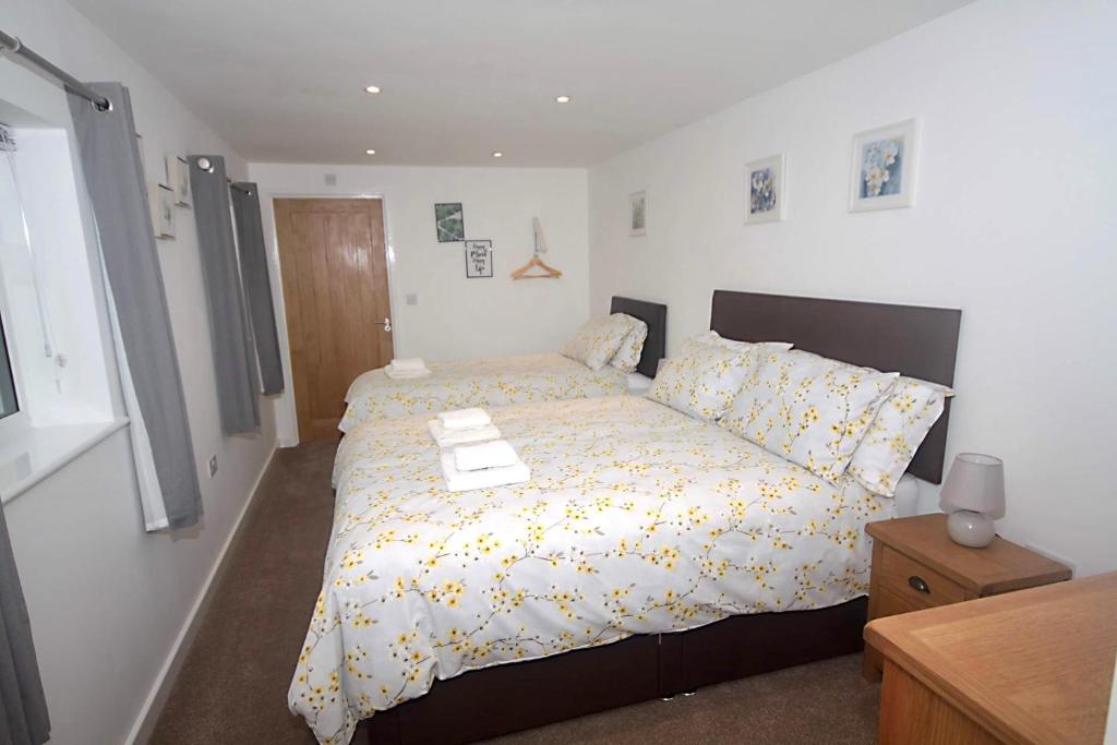 1 dormitorio con 1 cama con edredón amarillo y blanco en No 28C St Benedict en Glastonbury
