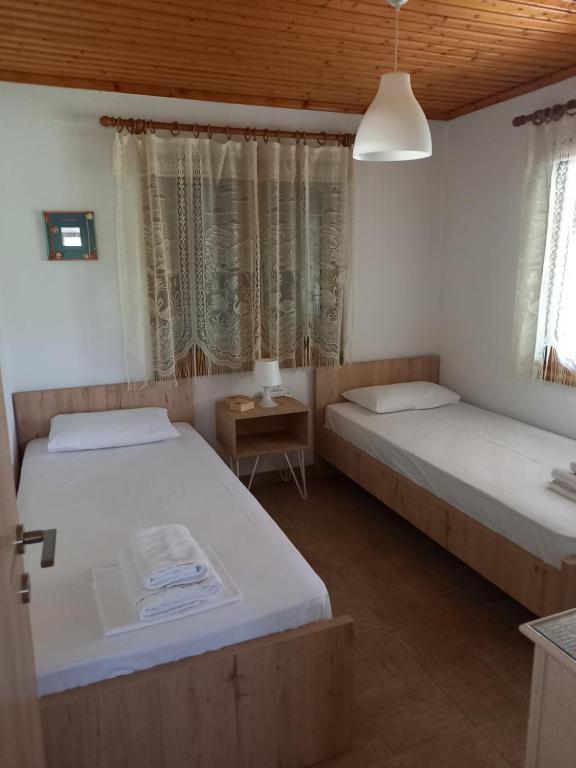 um quarto com 2 camas e uma mesa com um candeeiro em Villa Niki em Neos Marmaras