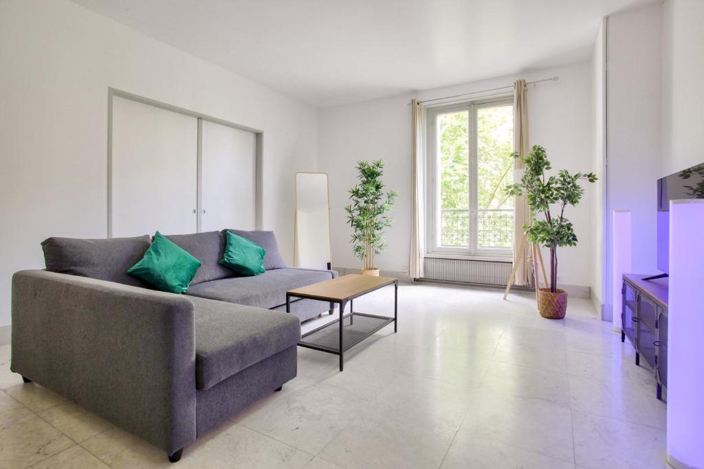 a living room with a couch and a table at 2 Bedrooms Tour Eiffel Rapp in Paris