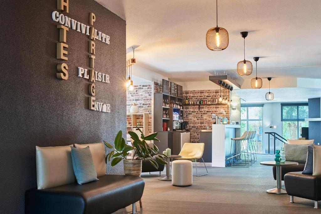 a lobby with couches and chairs and a sign that reads community law plus justice at Kyriad Lille Gare - Grand Palais in Lille