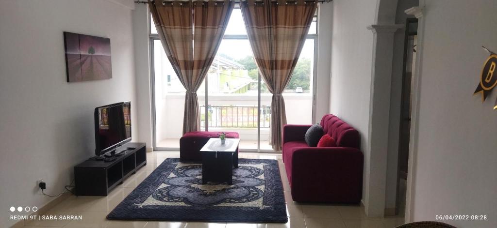 Sala de estar con 2 sillas rojas y TV en D'Zara Homestay, en Sepang