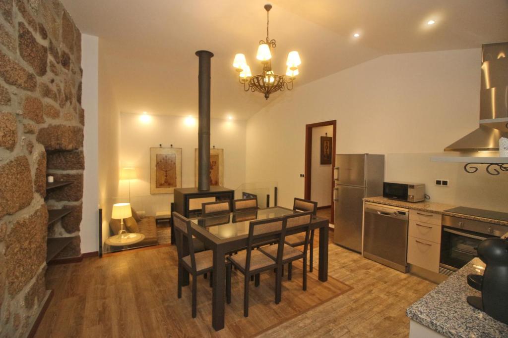 une cuisine avec une table et des chaises dans une pièce dans l'établissement Casa da Lameira II by Gerês Casas, à Gerês