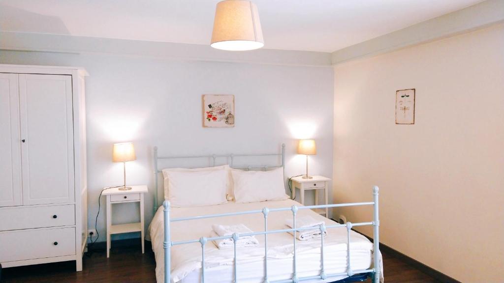 ein Schlafzimmer mit einem Bett mit zwei Nachttischen und zwei Lampen in der Unterkunft Gîte Chez Julie in Sarlat-la-Canéda