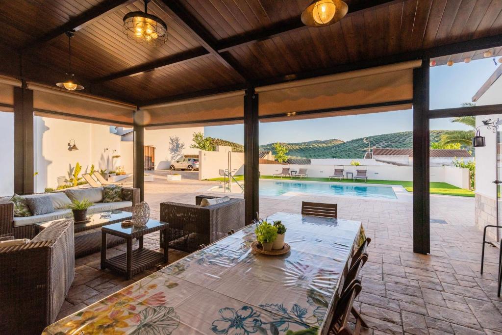 uma sala de estar com uma mesa e uma piscina em La Era Gran casa de vacaciones para grupos adaptada a vuestras necesidades em Rute