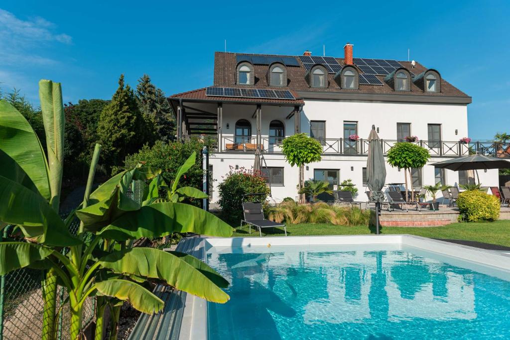 una casa con piscina frente a una casa en Katzer Villa, en Badacsonytördemic