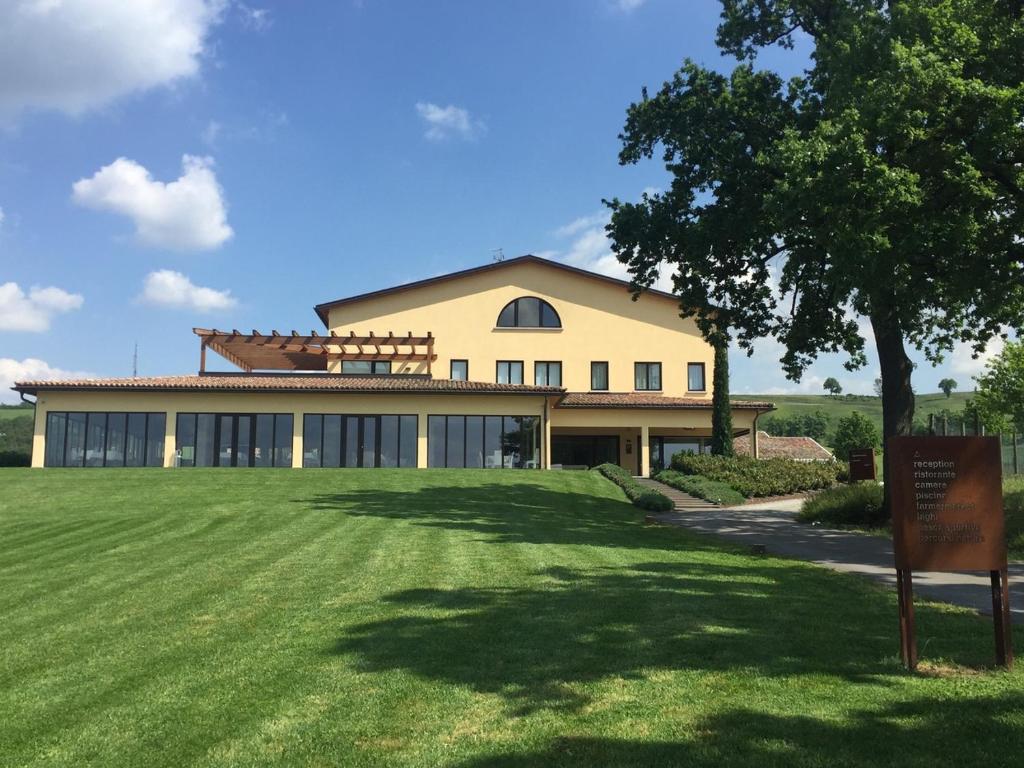 une grande maison avec une grande pelouse devant elle dans l'établissement Pianderna Agriwellness, à Scandiano