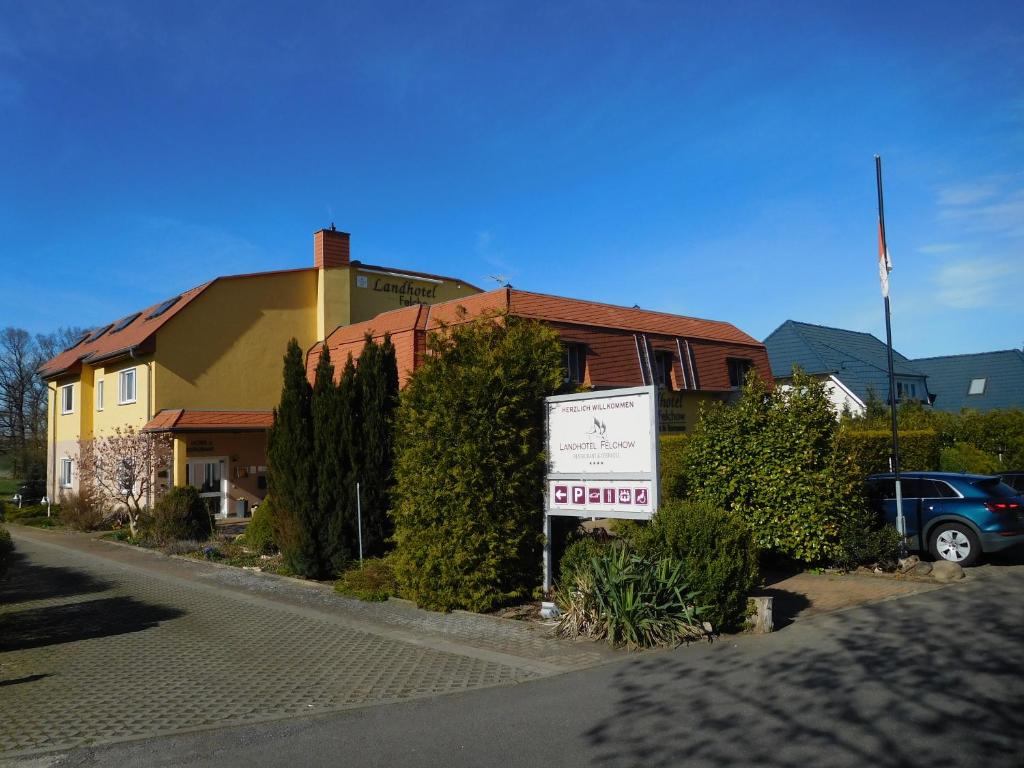 un panneau devant un bâtiment avec une maison dans l'établissement Landhotel Felchow, à Felchow