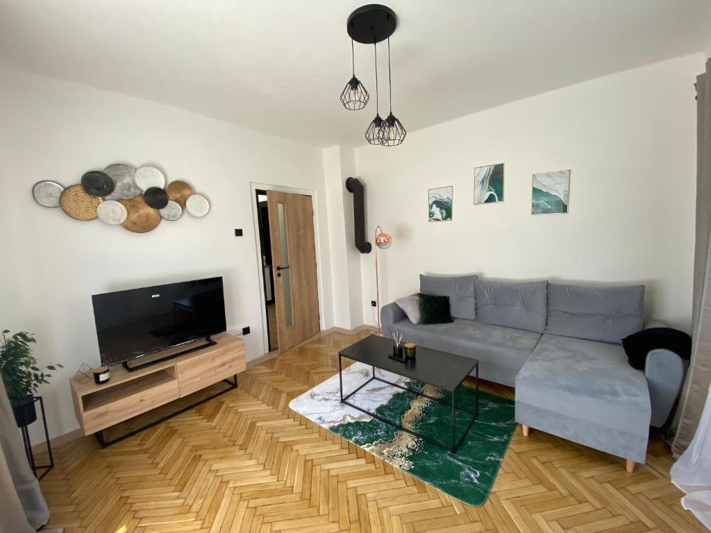 a living room with a couch and a tv at Panda apartmán Frýdštejn in Frýdštejn