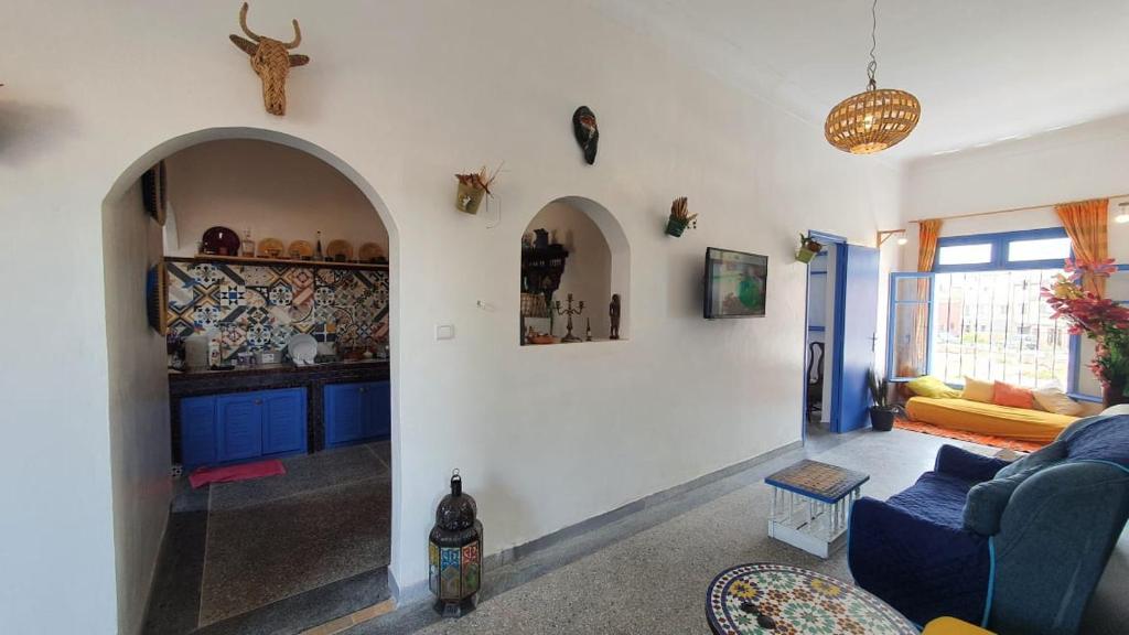 a living room with a blue couch and a kitchen at Dar ziane 1 in El Jadida