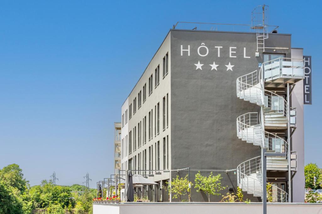 a building with a hotel sign on the side of it at Lorraine Hôtel Nancy Ouest - Laxou in Nancy