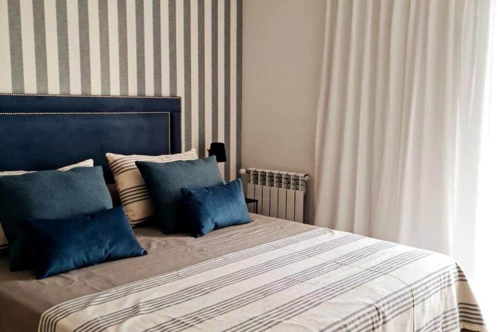 ein Schlafzimmer mit einem großen Bett mit blauen Kissen in der Unterkunft Sweet Dreams III Sanatorio Junín IMEC in Junín
