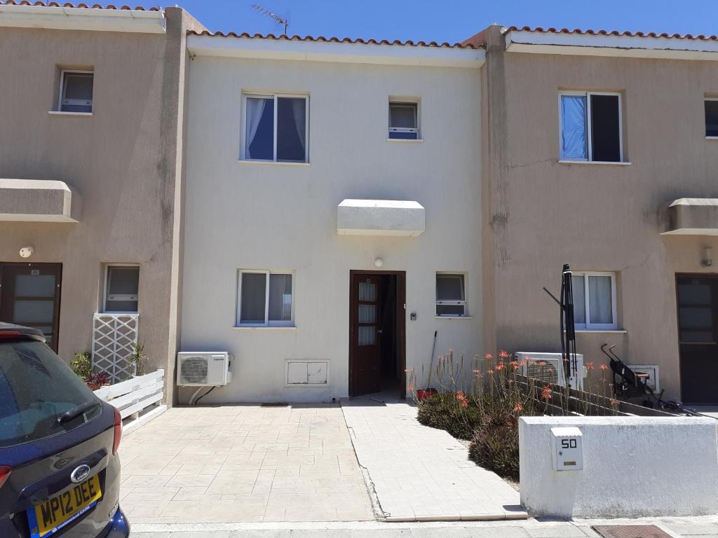 un edificio con una porta e una macchina parcheggiata di fronte di Beautiful 2-Bed House in Mandria paphos a Mandria