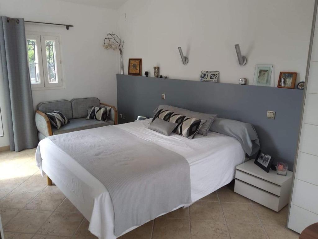 ein Schlafzimmer mit einem großen Bett und einem Sofa in der Unterkunft La Lézardière in Paradou