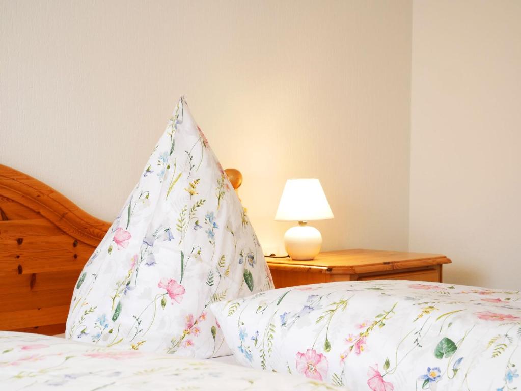 ein Bett mit einem Kissen und einem Tisch mit einer Lampe in der Unterkunft Ferienwohnung Veronika Heilbock in Sankt Peter