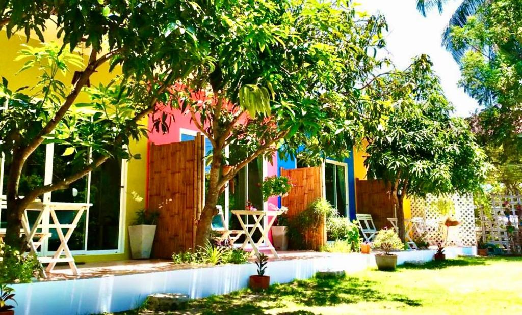 een kleurrijk huis met een tafel en stoelen in een tuin bij Namaste resort in Sam Roi Yot