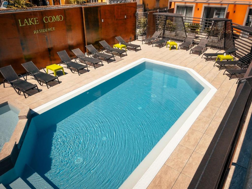 una gran piscina con sillas y una mesa en Residence Lake Como, en Colico