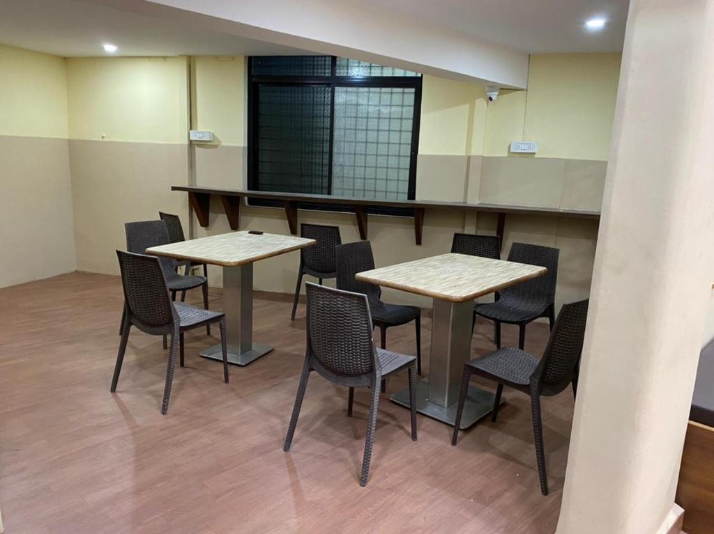 a room with two tables and chairs in it at City Stay AC Deluxe Hostel in Madgaon
