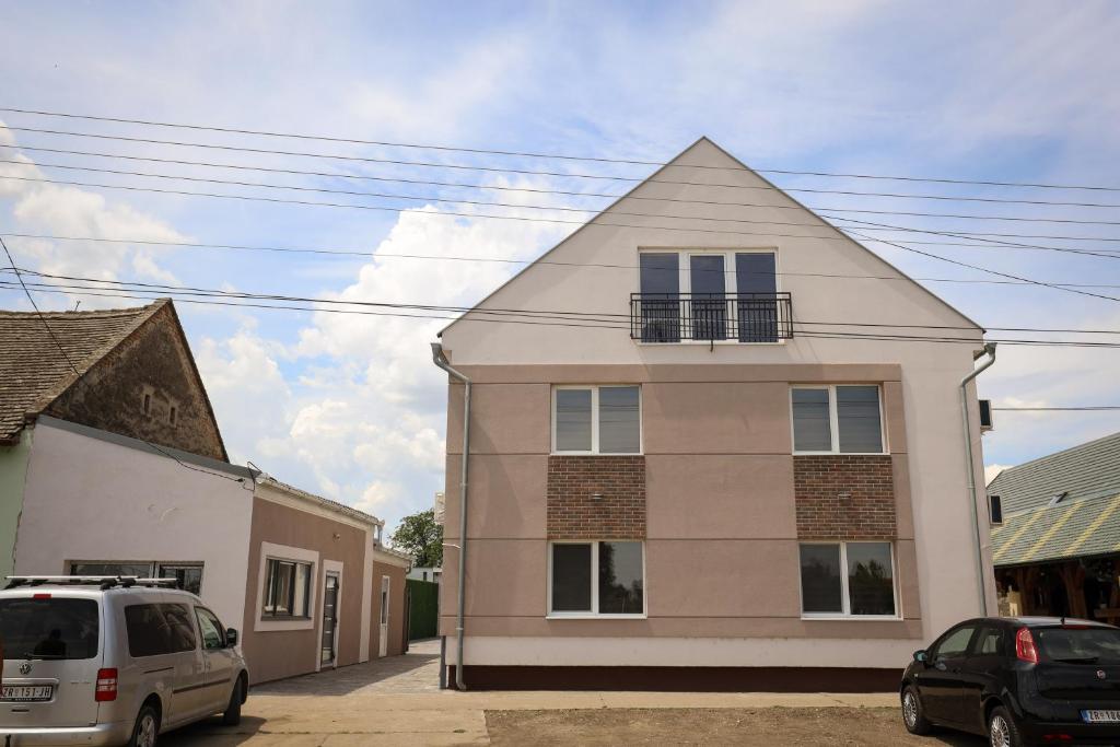 a white house with a gambrel roof at Domaćin Komšijska Gostiona in Zrenjanin