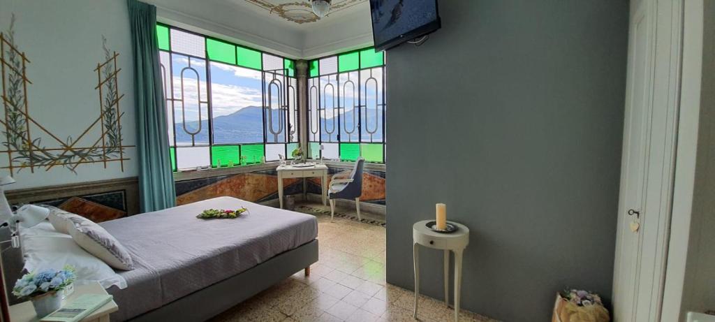 Schlafzimmer mit einem Bett und Buntglasfenstern in der Unterkunft Hotel La Rondinella in Cannero Riviera