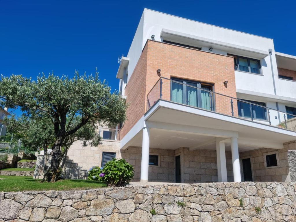 una casa con una pared de piedra delante de ella en Florindo - Lafões Guest House, en Oliveira de Frades