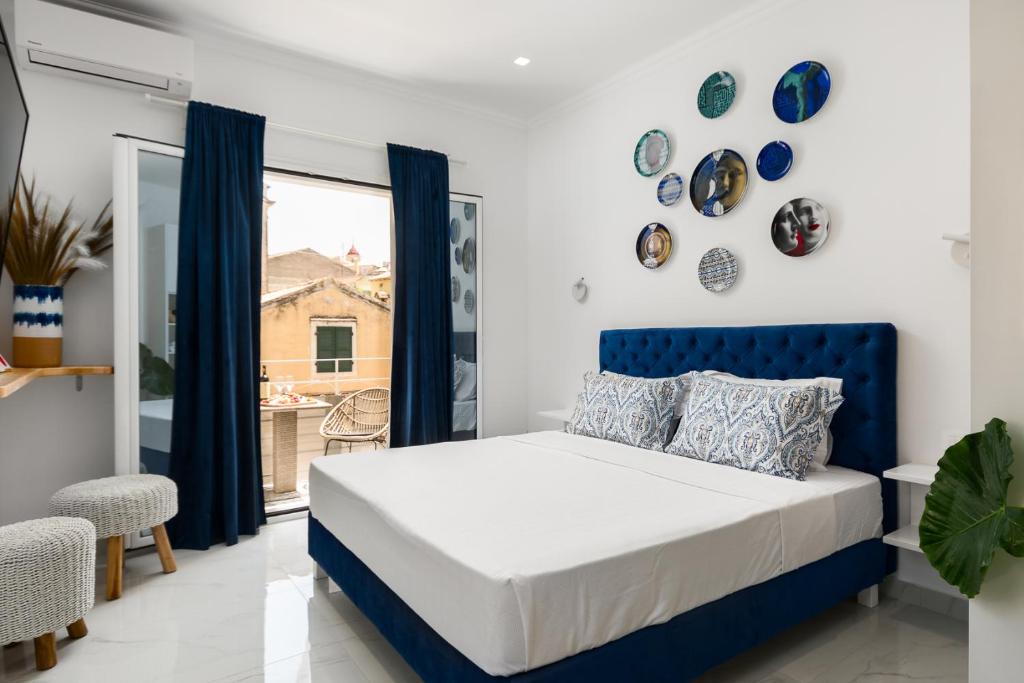 a bedroom with a blue bed and a window at Koukounara Apartments Collection by Konnect, Old Corfu Town in Corfu