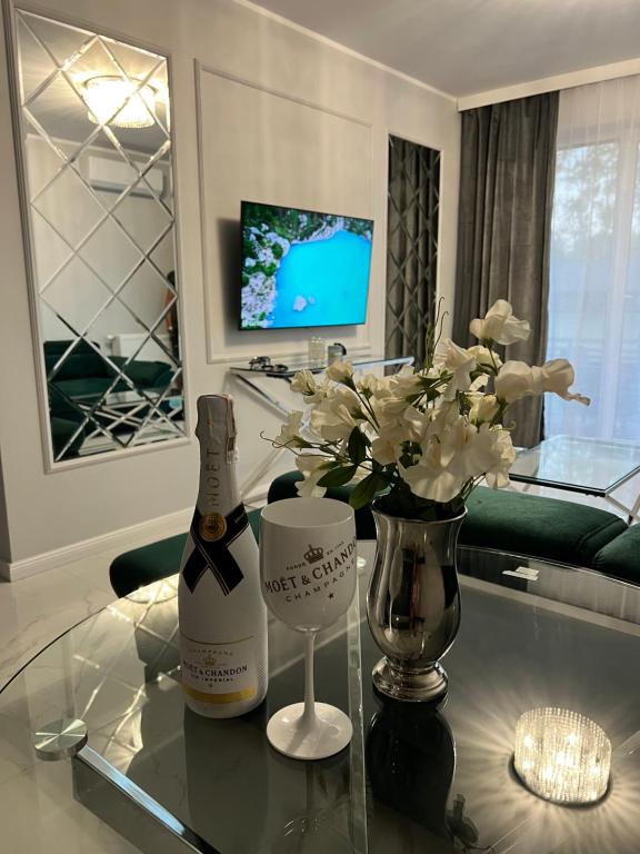 butelkę szampana na szklanym stole w salonie w obiekcie Awenturyn Apartament SAGARIS Dziwnów w Dziwnowie