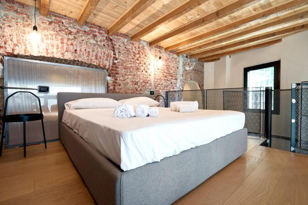 a bedroom with a large bed in a brick wall at LANCETTI Stylish Loft - hosted by Sweetstay in Milan