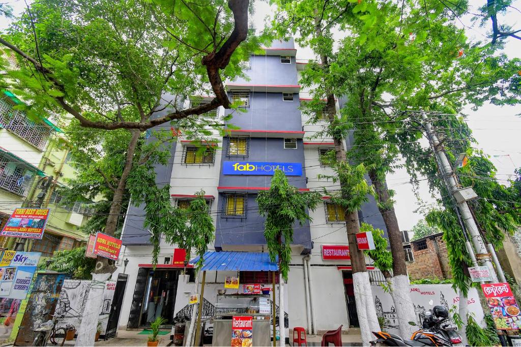 FabHotel Adri Hotel's في Dum Dum: مبنى ازرق على جانب شارع