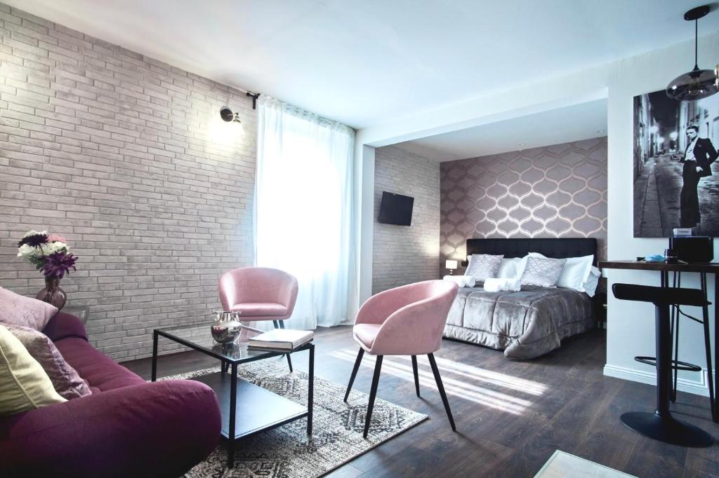 een slaapkamer met een bed en een bakstenen muur bij S H E N K I N ChicLife Design Apt next to the Museum in Bergamo