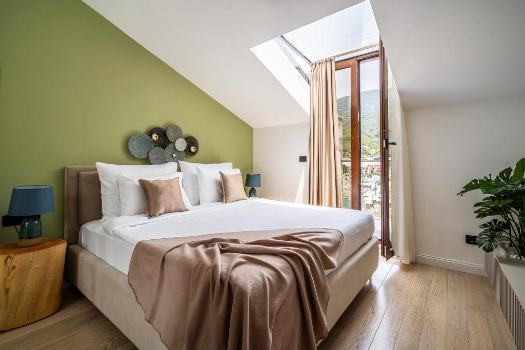 a bedroom with a large bed and a window at Blanche Cliff Apartments in Sveti Stefan