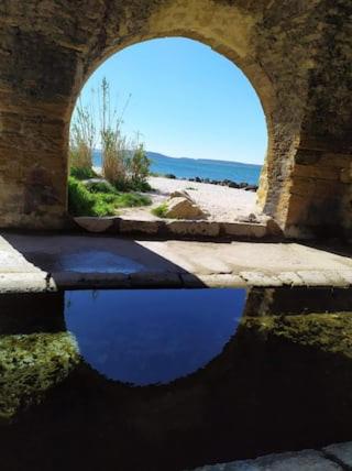 un pont avec une réflexion du ciel dans l'eau dans l'établissement Au pied du Baou, à Saint-Chamas
