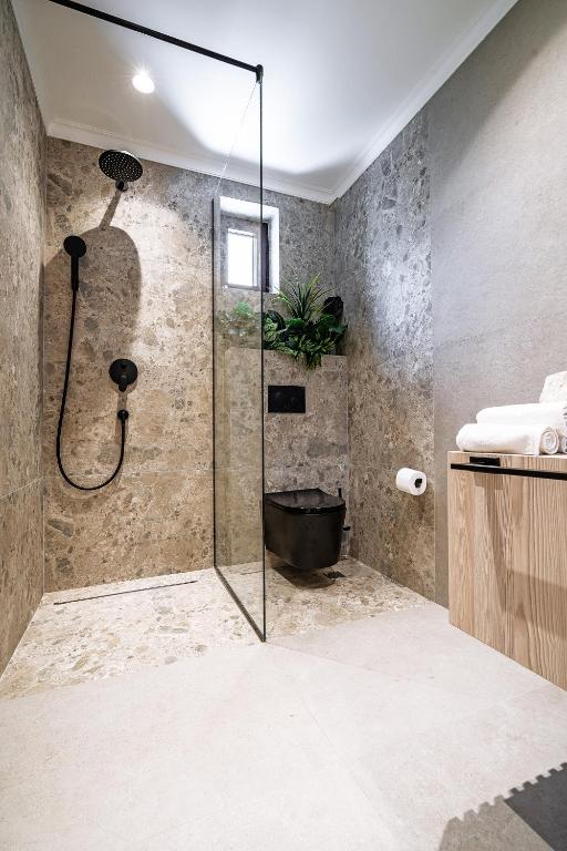 a bathroom with a shower with a black tub at Blanche Cliff Apartments in Sveti Stefan