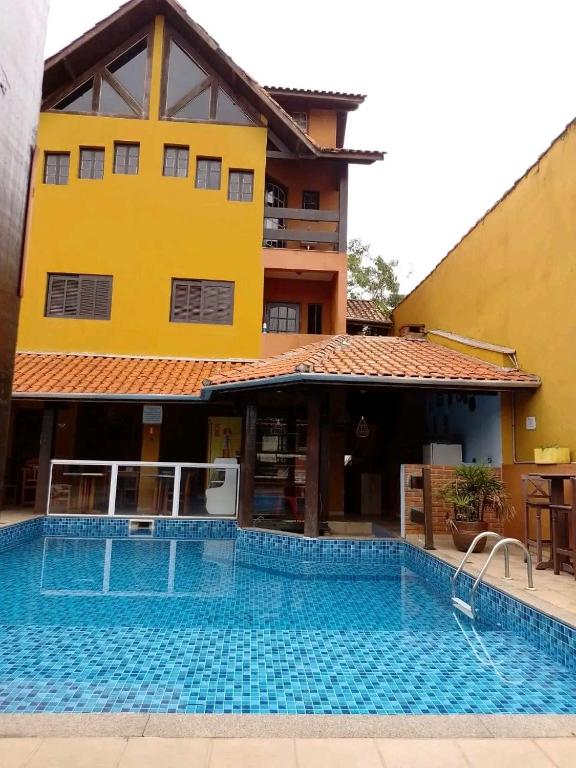 a large swimming pool in front of a building at Pousada Morada Dusanjos in Caraguatatuba
