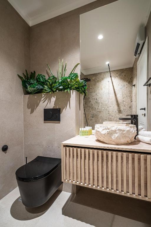 a bathroom with a black tub and a sink at Blanche Cliff Apartments in Sveti Stefan