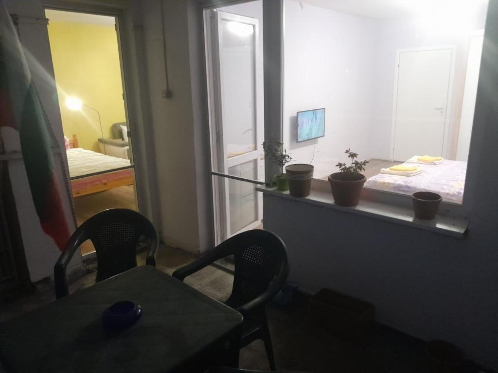 een kamer met een tafel, 2 stoelen en een spiegel bij Summer Burgas Appartment in Boergas