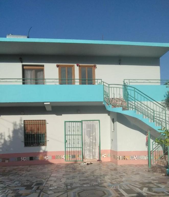 a building with a blue staircase on the side of it at Home to rent-Casa vacanza-Shtepi pushimesh-KONDAJ in Orikum