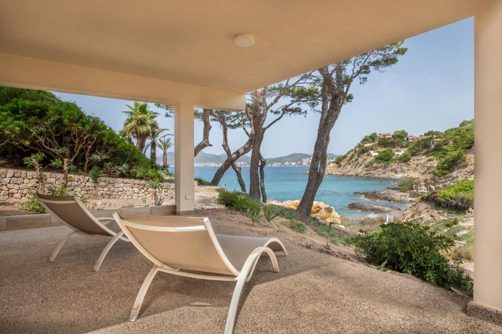 two chairs sitting on a porch looking out at the ocean at Villa Rivo - Costa de la Calma in Costa de la Calma