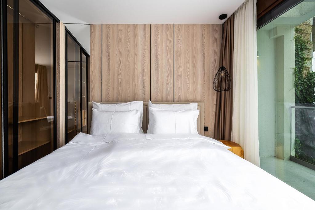 a large bed with white sheets and pillows at Blanche Cliff Apartments in Sveti Stefan
