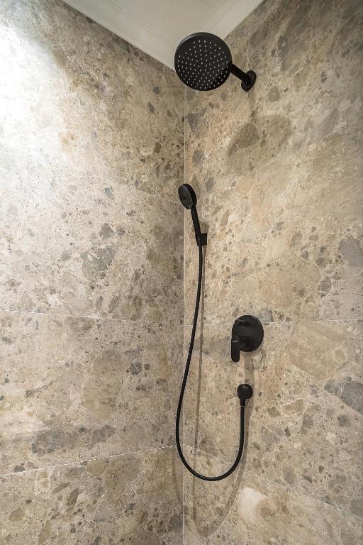 a shower with a shower head in a bathroom at Blanche Cliff Apartments in Sveti Stefan