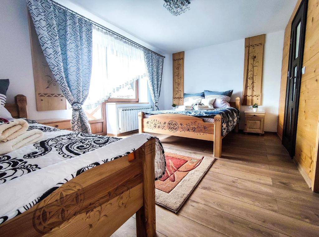 Bańska Niżna的住宿－Szostak Apartament，一间卧室设有两张床和窗户。