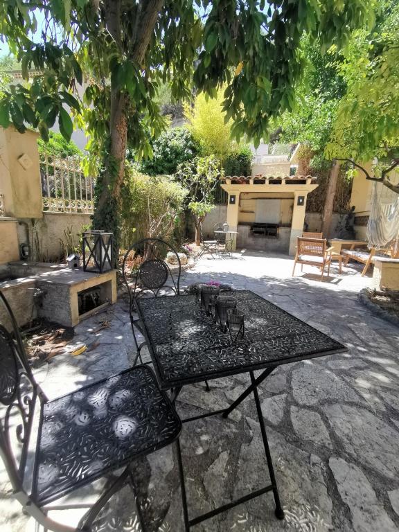 un patio avec une table et des chaises sous un arbre dans l'établissement Chambre privée luxueuse Villa Monte 0ropa, à Nice
