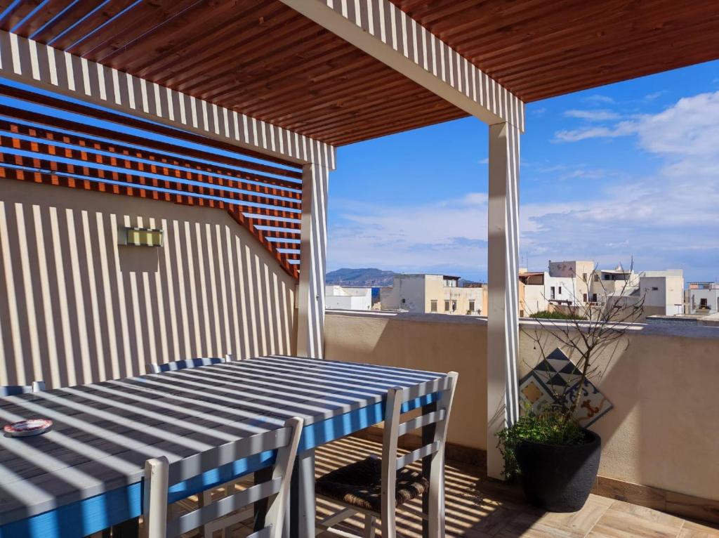 una mesa y sillas azules y blancas en el balcón en FAVIGNANA IN CENTRO, en Favignana