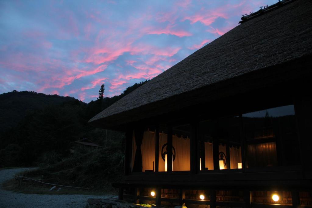 a building with a sunset in the background at Chiiori in Miyoshi