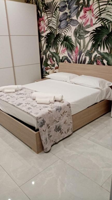 łóżko z białą pościelą i poduszkami w pokoju w obiekcie Nase e cane home Napoli w mieście Neapol