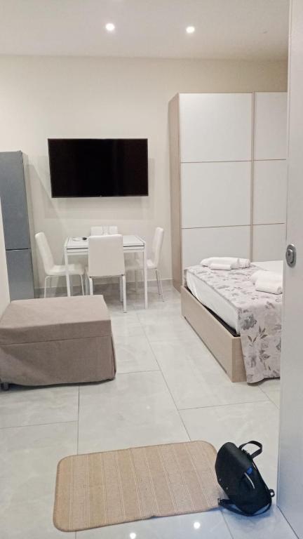 sypialnia z łóżkiem, stołem i telewizorem w obiekcie Nase e cane home Napoli w mieście Neapol