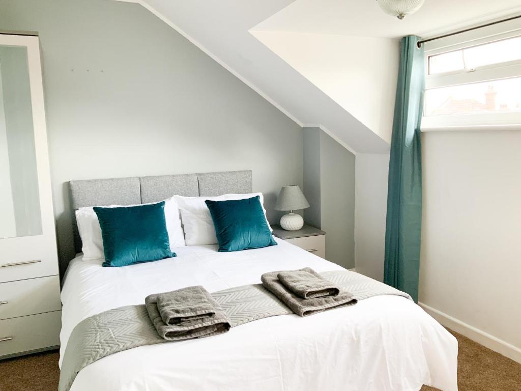 1 dormitorio con 1 cama grande con almohadas azules en Thornbury House, en Southampton