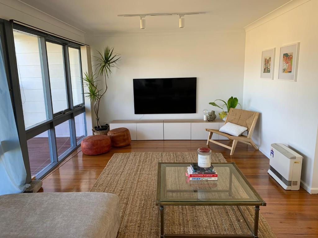 a living room with a tv and a coffee table at The Beachcomber in Sanctuary Point