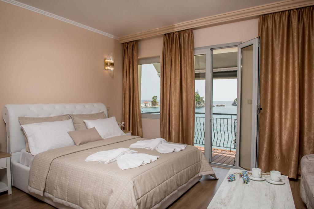 sypialnia z dużym łóżkiem i balkonem w obiekcie Oniro PargaTown Luxury Suites w mieście Parga